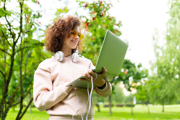 женщина работает на открытом воздухе ноутбука в парке
 