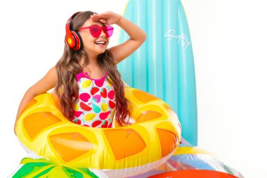 Plaj tarzında beyaz arka planda poz veren tatlı küçük kız.  