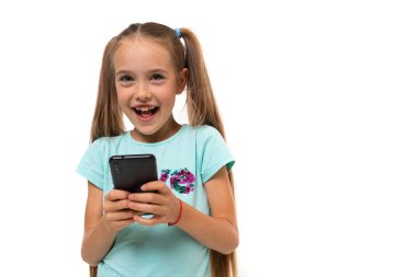 Cep telefonu olan küçük kız beyazda izole edilmiş. 