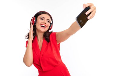 Kırmızılı güzel kadın, kulaklık ve telefonla. 