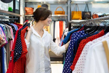 Mağazada kıyafet seçen güzel bir kadın. 