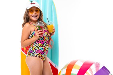 Plaj tarzında beyaz arka planda poz veren tatlı küçük kız.  