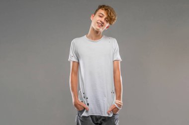 Yakışıklı duygusal genç stüdyoda griye karşı poz veriyor. 