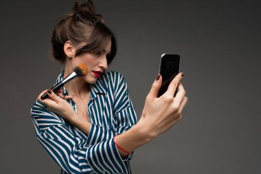 Güzel esmer kadın makyaj yapıyor. 