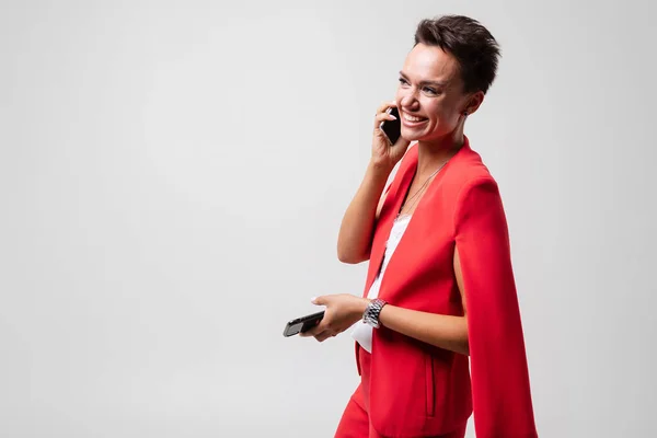 Mujer Negocios Traje Rojo Posando Con Teléfonos Móviles Sobre Fondo —  Fotos de Stock