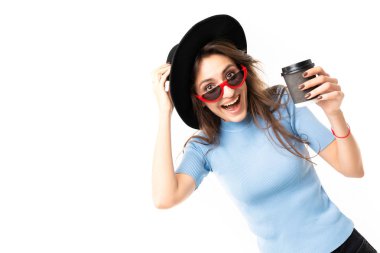 Genç ve güzel bir kadın şapkayla kahveyle poz veriyor 