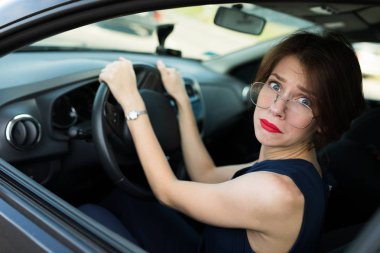 Arabada poz veren genç ve güzel bir kadın. 