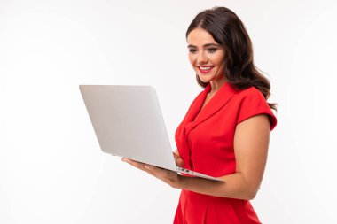 Dizüstü bilgisayarı olan kırmızı elbiseli güzel kadın. 