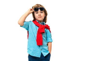 Stüdyoda poz veren şirin, modaya uygun küçük bir çocuk. 