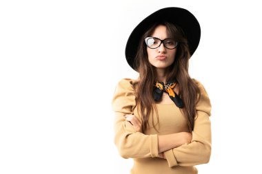 Stüdyoda güzel bir kadın beyaz şapkalı ve gözlükle poz veriyor. 