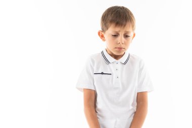 Stüdyoda beyazlara karşı poz veren sevimli çocuk.