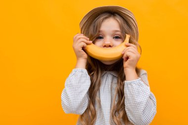 cute little girl posing against orange background