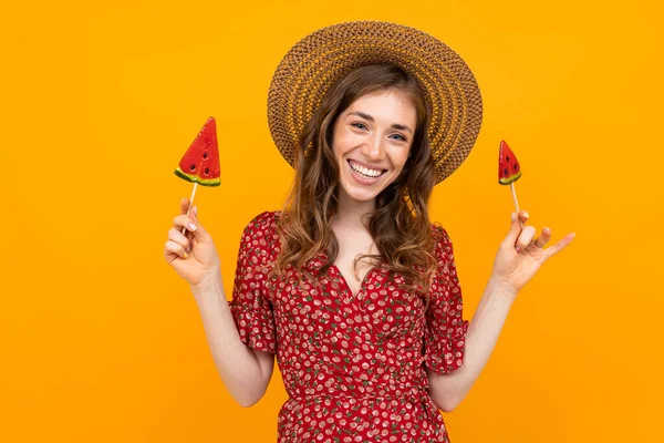 young woman with lollipops posing against orange