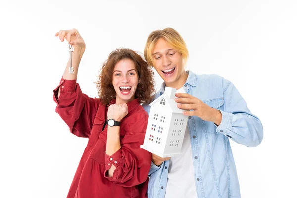 Woman and man posing with house layout against white background