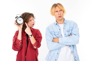 Woman and man posing against with alarm clock white background 