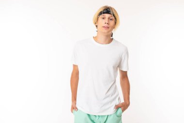 young blond man posing against white background  