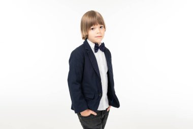 Stüdyoda poz veren zarif küçük bir çocuk.