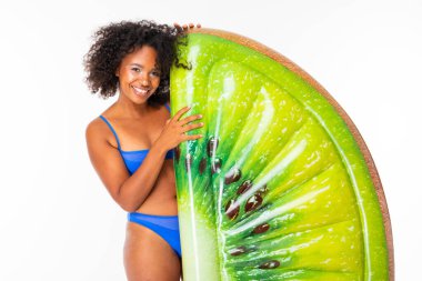 Mayo giyen Afrikalı kadın beyaz arka planda şişme yatakla poz veriyor. 