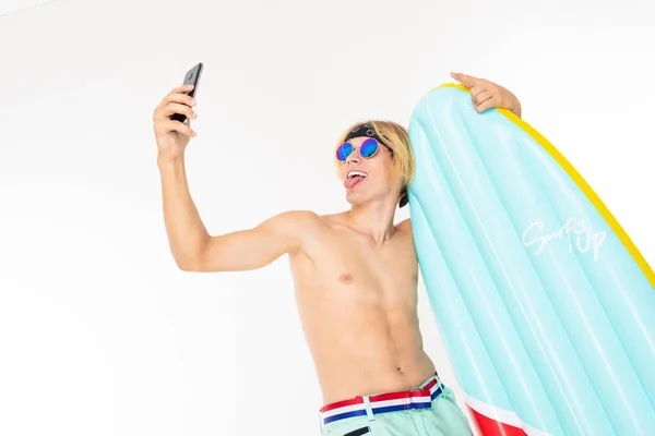 年轻的金发男子赤身裸体 戴着太阳镜 头戴气垫 手持白色背景手机 — 图库照片
