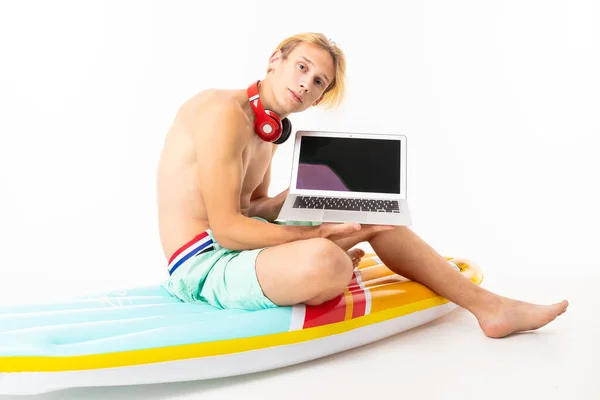 Jovem Loiro Homem Peito Sentado Colchão Com Laptop Contra Fundo — Fotografia de Stock
