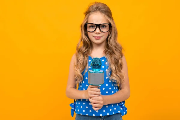Nettes Kleines Mädchen Mit Mikrofon Posiert Gegen Orange — Stockfoto