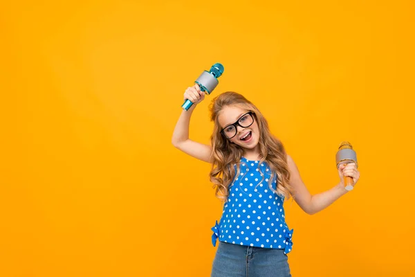 Nettes Kleines Mädchen Posiert Mit Zwei Mikrofonen Vor Orangefarbenem Hintergrund — Stockfoto