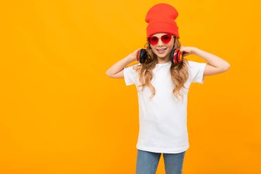 Stüdyoda turuncu arka planda poz veren güzel bir kız.