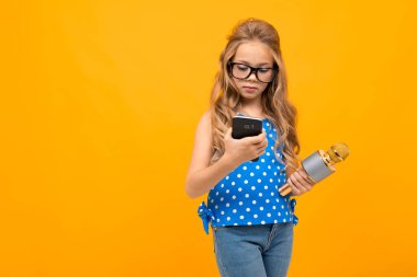 Telefonu ve mikrofonu olan küçük kız.