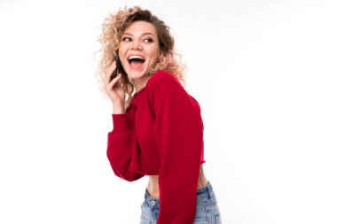 Beyaz arka planda cep telefonuyla poz veren genç kadın  