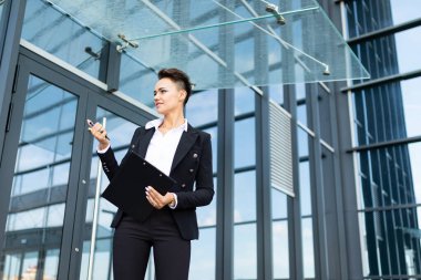 İş kadını iş yapısına karşı poz veriyor