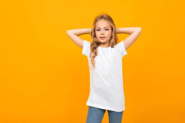 Roztomilá Holčička Džínách Bílé Tričko Pózující Proti Oranžovému Pozadí — Stock fotografie