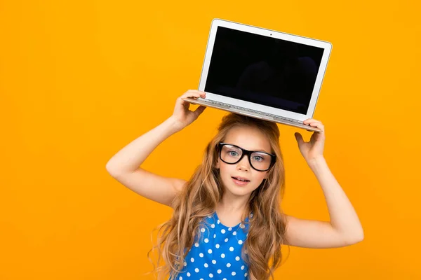 Turuncu Arka Planda Gözlüklü Dizüstü Bilgisayarlı Küçük Kız — Stok fotoğraf