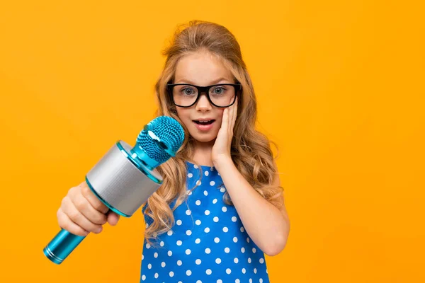 Cute Little Girl Mikrofonem Pozowanie Przeciwko Pomarańczowy — Zdjęcie stockowe
