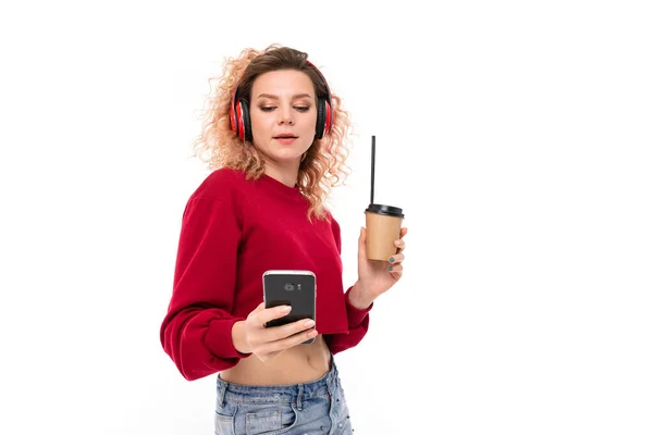 beautiful blonde girl with headphones, phone and coffee