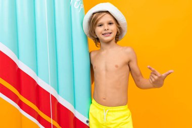 Portakala karşı şişme yatağı olan sevimli küçük çocuk. 