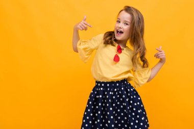 Turuncuya karşı poz veren hoş, şık bir kız. 