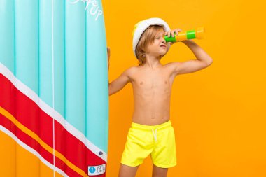 Portakala karşı şişme yatağı olan sevimli küçük çocuk. 