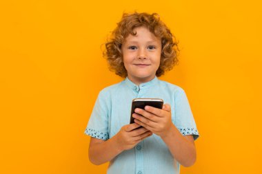 Küçük çocuk turuncu arka planda poz veriyor 