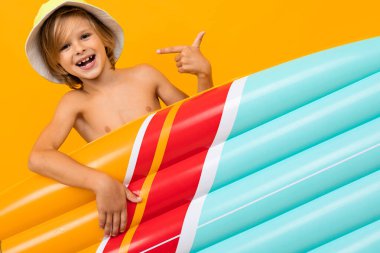 Portakala karşı şişme yatağı olan sevimli küçük çocuk. 