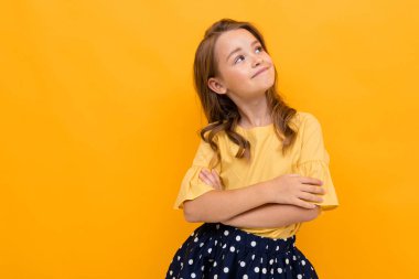 Turuncuya karşı poz veren hoş, şık bir kız. 