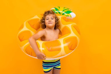 Turuncu arka planda lastik halkalı şirin bir çocuk. 