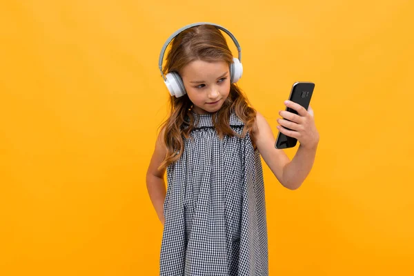 Linda Niña Escuchando Música Posando Sobre Fondo Naranja — Foto de Stock