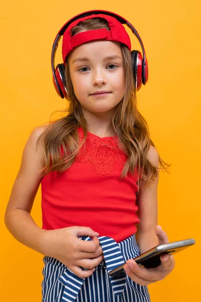 Cute Little Girl Słuchanie Muzyki Pozowanie Pomarańczowym Tle — Zdjęcie stockowe