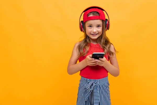 Cute Little Girl Słuchanie Muzyki Pozowanie Pomarańczowym Tle — Zdjęcie stockowe