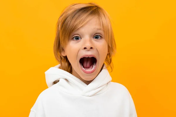 Emotionele Jongen Wit Hoodie Poseren Tegen Oranje Achtergrond — Stockfoto