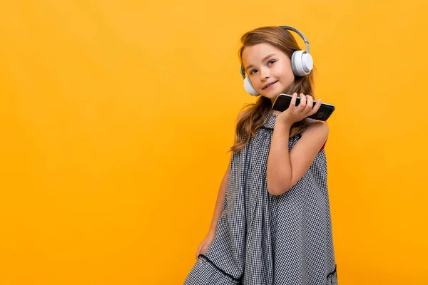 Linda Niña Escuchando Música Posando Sobre Fondo Naranja — Foto de Stock