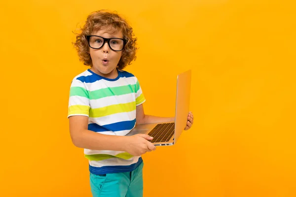 handsome boy with laptop against orange background
