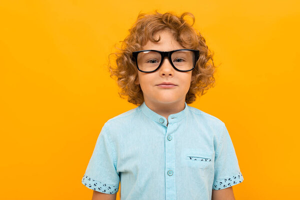 little boy posing against orange background 