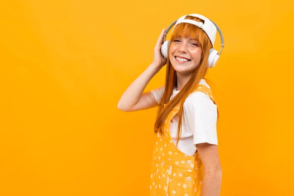 Alegre Jengibre Chica Escuchar Música Posando Sobre Naranja Fondo — Foto de Stock