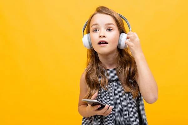 Linda Niña Escuchando Música Posando Sobre Fondo Naranja — Foto de Stock